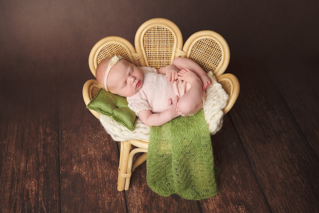 Ein Baby liegt schlafend auf kleinem Rattansessel, Neugeborenenfotos Babyfotos Neugeborenenfotografie Newborn Shooting Babyfotografie Ingolstadt Mandy Limbach Fotografie
